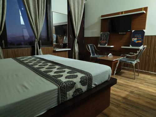 a bedroom with a bed and a desk and a computer at The Maiden's Blush in Chachyot