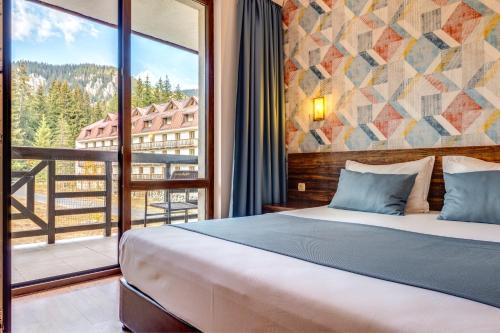 una camera da letto con un letto e una grande finestra di Oak Residence Hotel & Relax a Smoljan