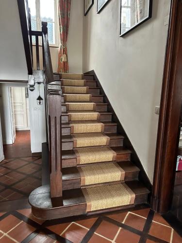 a wooden staircase in a room with a hallway at CHATEAU ROUTGER in Sainte Marie de Gosse