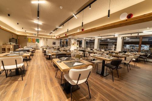a restaurant with tables and chairs in a room at Riserva Bianca Limone Hotel & SPA in Limone Piemonte