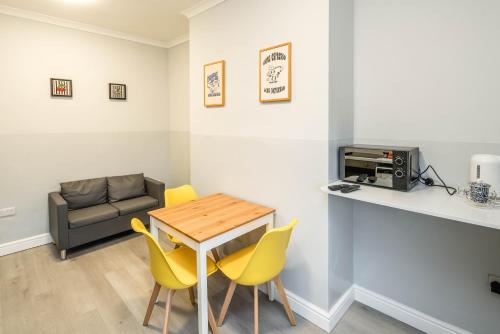 a living room with a table and chairs and a couch at Free parking, 2 beds,close to train station in Bedford