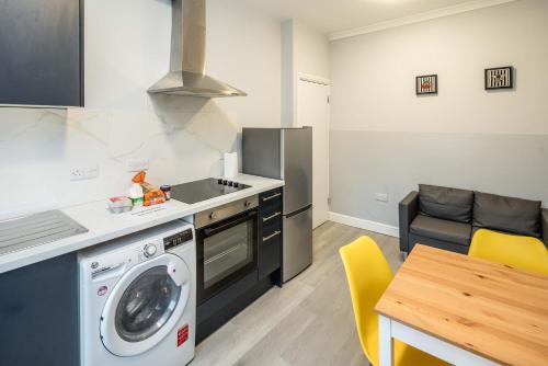 a kitchen with a washing machine and a stove at Free parking, 2 beds,close to train station in Bedford