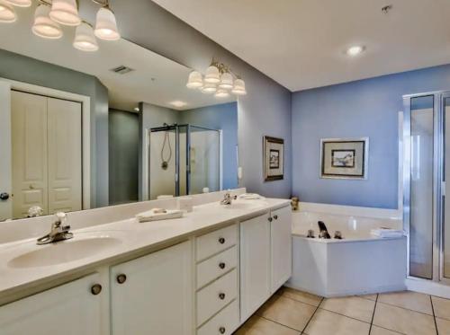 a bathroom with two sinks and a large mirror at Bodacious Beach Retreat Condo in Destin in Destin