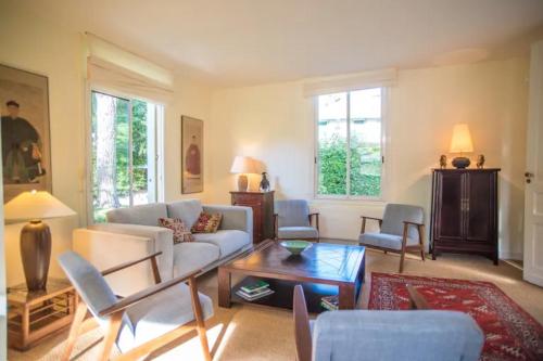 un salon avec un canapé, des chaises et une table dans l'établissement Oasis moderne avec piscine chauffée au coeur de la ville d'hiver, à Arcachon