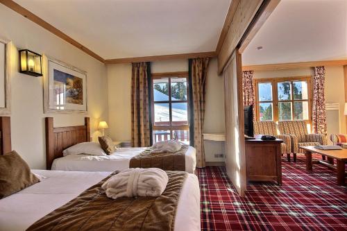 une chambre d'hôtel avec deux lits et un bureau dans l'établissement ARC 1950, Exposition Sud, Vue Pistes de skis & Montagnes, à Arc 1950