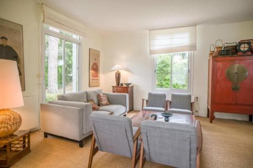un salon avec un canapé et des chaises dans l'établissement Oasis moderne avec piscine chauffée au coeur de la ville d'hiver, à Arcachon
