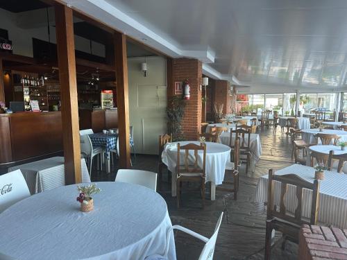 een eetkamer met witte tafels en stoelen en een restaurant bij Enfrente al mar Servicio de playa Limpieza diaria Estacionamiento Sábanas y toallas Gimnasio Recepción 24 hs A pasos del puerto y Gorlero in Punta del Este