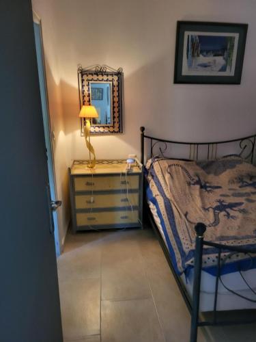 une chambre avec un lit et une commode avec un miroir dans l'établissement maison à Cavalaire sur mer, à Cavalaire-sur-Mer
