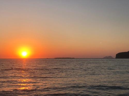 un tramonto sull'oceano con il sole che tramonta di Perseus Sailing Cruises a Souda (Suda)