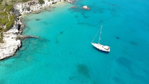una barca in acqua accanto a una spiaggia di Perseus Sailing Cruises a Souda (Suda)