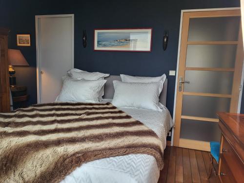 une chambre avec un lit avec une couverture rayée dans l'établissement Appartement de Charme avec terrasse proche 5eme arrdt, à Paris