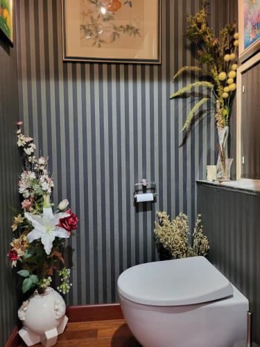 La salle de bains est pourvue de toilettes et de fleurs sur le mur. dans l'établissement Appartement de Charme avec terrasse proche 5eme arrdt, à Paris