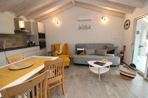 una cucina e un soggiorno con un divano e un tavolo di arena's casa vacanze a La Caletta