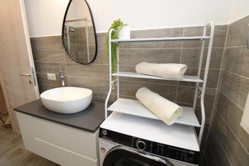 bagno con lavatrice e specchio di arena's casa vacanze a La Caletta