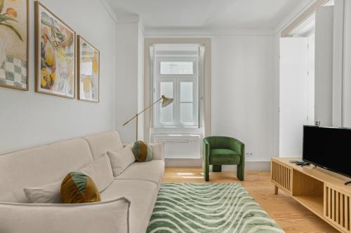 a living room with a couch and a television at Avenida Boutique Apartments in Lisbon