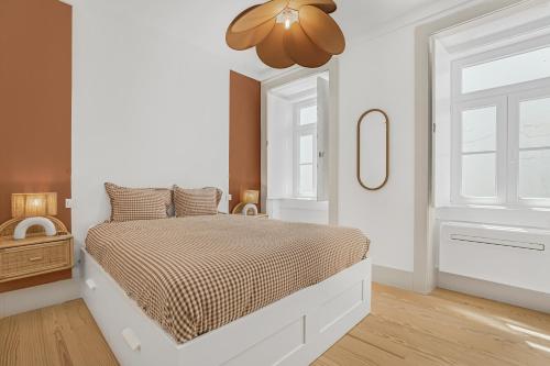 a white bedroom with a bed and a ceiling at Avenida Boutique Apartments in Lisbon