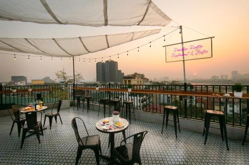 a patio with tables and chairs on a balcony at Westlake Pearl Apartment - Hotel & Pearl Spa in Hanoi