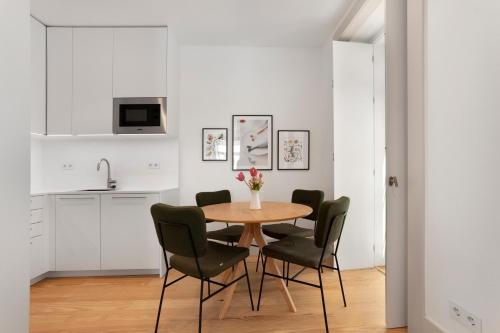 a kitchen and dining room with a table and chairs at Avenida Boutique Apartments in Lisbon
