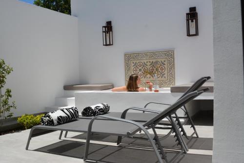 a woman sitting at a white table with chairs at Viamonte Winery Lodge in Chacras de Coria