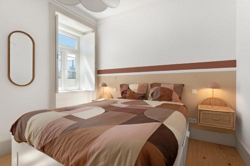 a bedroom with a large bed and a window at Avenida Boutique Apartments in Lisbon