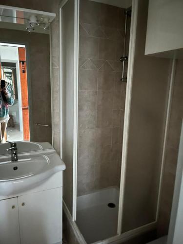 une personne prenant une photo d'une salle de bains avec douche dans l'établissement Sea Pearl apartment Cannes, à Cannes
