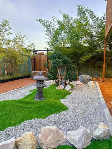 a garden with rocks and a fountain in a yard at Aimei Bang Saray in Bang Sare