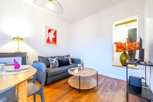 un salon avec un canapé et une table dans l'établissement L'Escale Parisienne Charmant T2 proche métro et Paris, à Pantin
