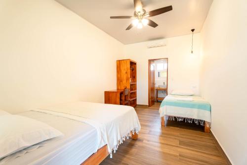 a bedroom with two beds and a ceiling fan at Beach Break Hotel & Surf Camp de Playa Venao in Playa Venao