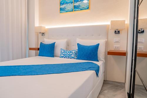 a bedroom with a large bed with blue pillows at Xeliter Cana Rock Punta Cana in Punta Cana