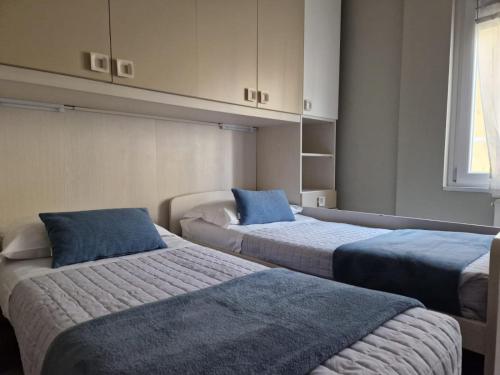 a room with two beds with blue pillows at BGY Central Apartments in Bergamo