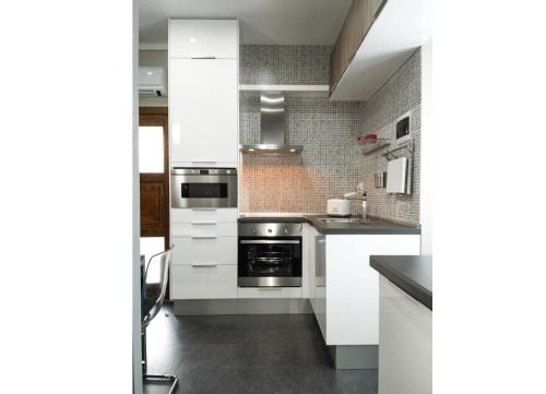 kuchnia z białymi szafkami i kuchenką w obiekcie Appartamento Elegante w mieście Cannero Riviera