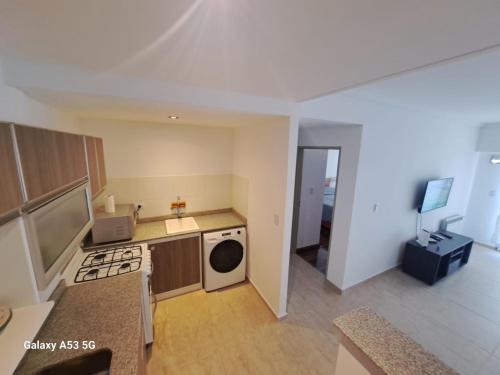 a kitchen with a washer and dryer in a room at Departamento a estrenar con pileta in Buenos Aires