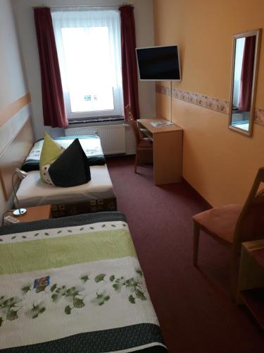 a hotel room with two beds and a window at Pension Tiffany in Chemnitz
