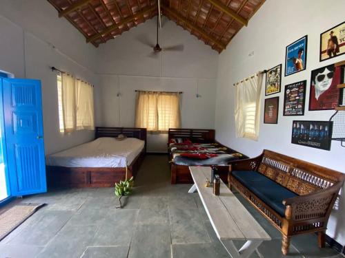 Un dormitorio con una cama y un sofá en una habitación. en Farmer's Deck Farmstay - Hill Top Villa, en Chanere