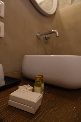a bathroom with a sink and a book on a counter at Relais Borgo Campello in Campello sul Clitunno
