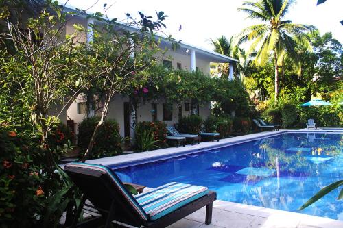 a swimming pool with a chair next to a house at Hotel Atelie del Mar in Monterrico