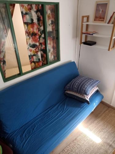 - un canapé bleu avec un oreiller dans l'établissement T2 -Cosy and Comfort in Paris - Montmartre, à Paris
