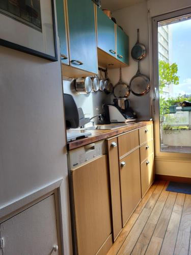 une petite cuisine avec un évier et une fenêtre dans l'établissement Appartement de Charme avec terrasse proche 5eme arrdt, à Paris