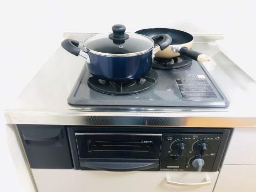 a blue pot on top of a stove at 桜並木と航空公園の近くにある閑静なお部屋 最大5名 t10 in Tokorozawa