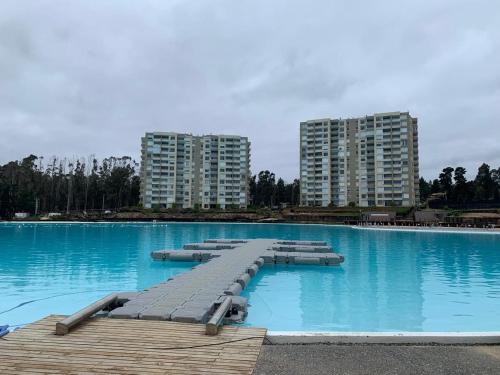 a large swimming pool with blue water and tall buildings at Hermoso Depto full equipado 2D y 2B vista al Mar, Laguna y Dunas in El Tabo