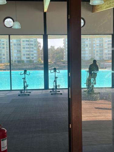 a man standing in a room with two exercise bikes at Hermoso Depto full equipado 2D y 2B vista al Mar, Laguna y Dunas in El Tabo