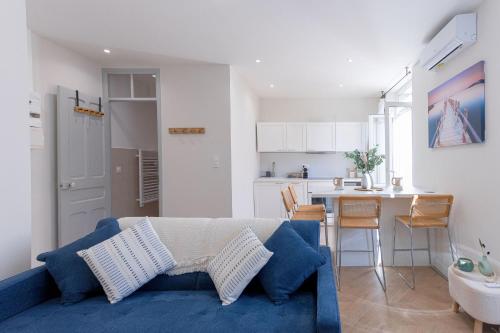 un salon avec un canapé bleu et une cuisine dans l'établissement Leandre Sardou by Halldis, à Cannes