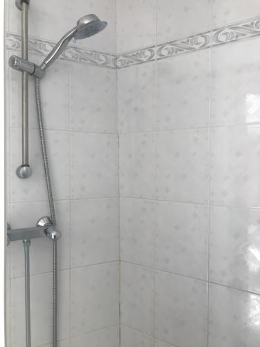 une douche avec pommeau de douche dans une salle de bain dans l'établissement Appartement ensoleillé belle vue dégagée, à Menton