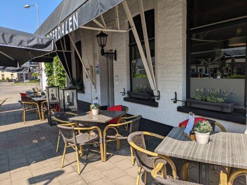 a patio with tables and chairs outside of a restaurant at Hotel Restaurant Roerdalen in Posterholt