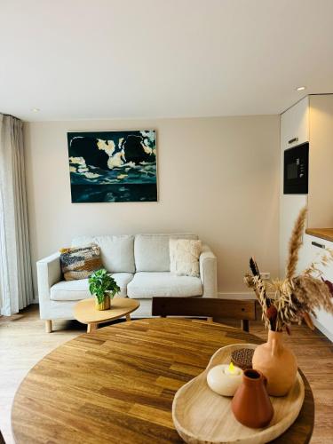 a living room with a couch and a table at Ocean Breeze - Noordwijk aan Zee in Noordwijk aan Zee