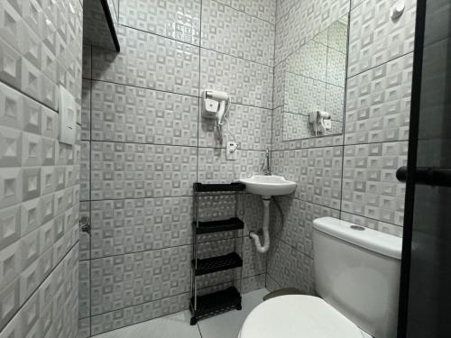 Un baño pequeño con inodoro y lavabo. en Ático com Ar Condicionado Q e F, en Ponta Grossa