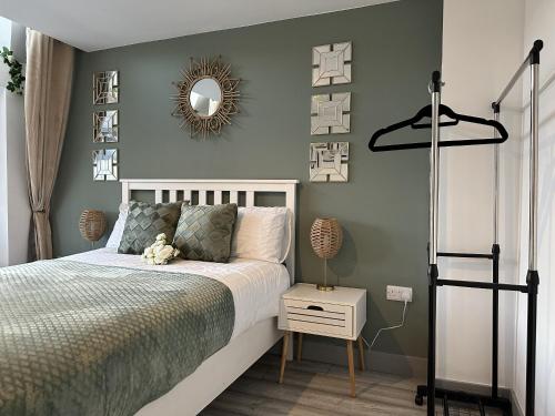 a bedroom with a bed and a mirror on the wall at Lilypad Suite - BHX Airport, NEC & HS2 in Solihull