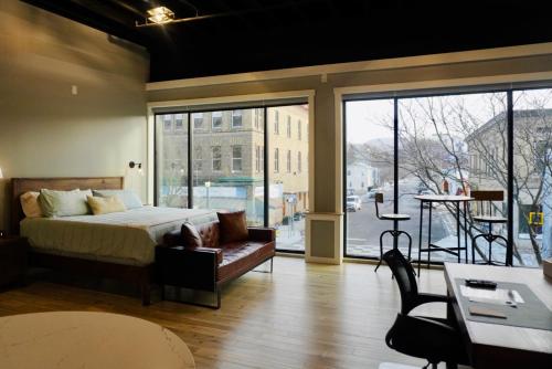 ワトキンズ・グレンにあるThe Benjamin Hotelのベッドとソファと窓のある寝室