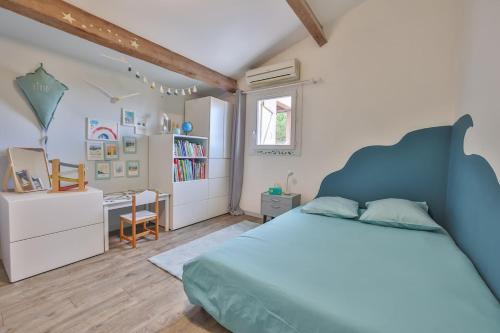 - une chambre avec un lit bleu et un bureau dans l'établissement Slow Villa, 5 chambres avec piscine, à Pérols