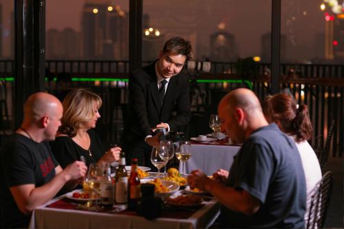 a group of people sitting around a table eating food at Westlake Pearl Apartment - Hotel & Pearl Spa in Hanoi